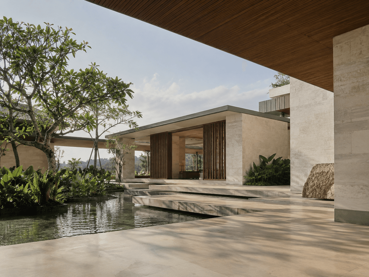 A tropical courtyard with stone terraces, a reflecting pool, and a timber canopy in warm afternoon light